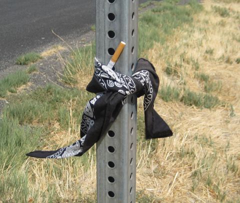 Kerchief tying cigarette to a signpost
