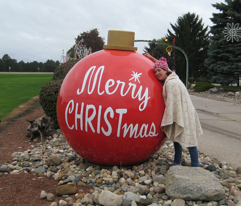 Woman standing next to large ornament