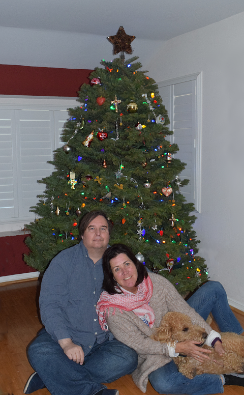 Couple with Dog, seated in front of a Christmas tree