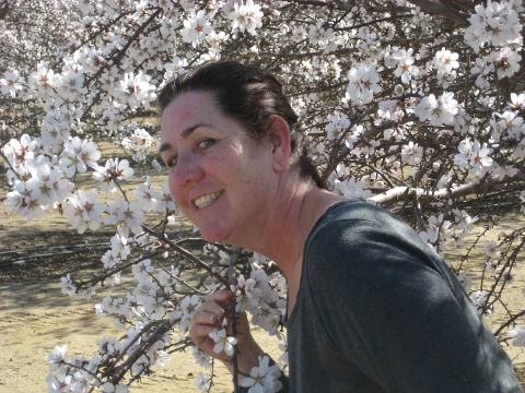 Woman standing in front of flowering almond tree