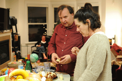 Couple, their faces etched with concern, looking at rolls on a dinner buffet