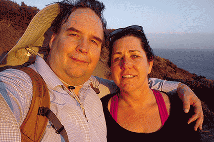 A couple stands infront of an oceanside cliff