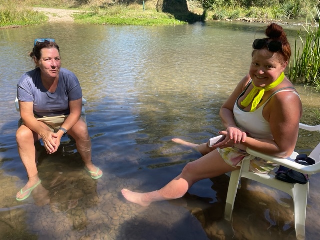 Two women in chairs in river